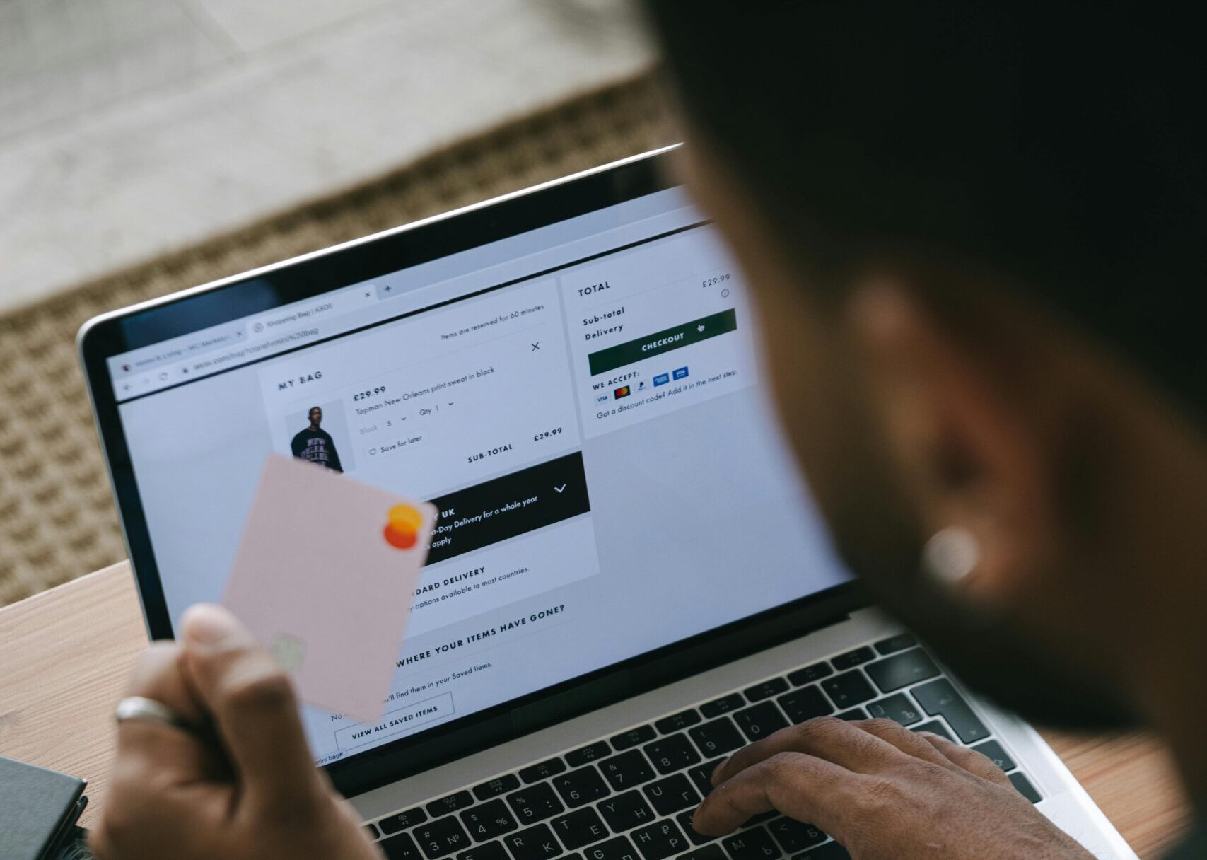 Person shopping online using a laptop and credit card.